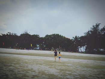 Children playing in park against sky