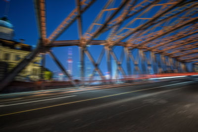 Light trails on road in city against sky