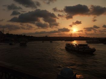 Silhouette boats in sea at sunset