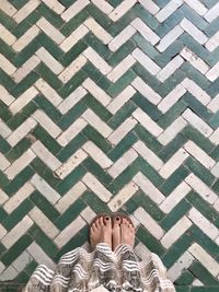 Low section of woman standing on tiled floor