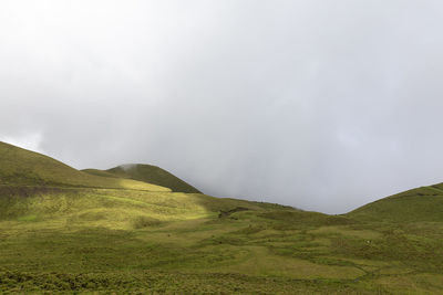 Scenic view of green landscape against sky