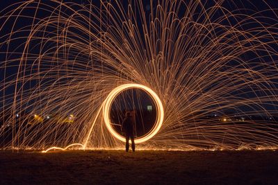 Person spinning wire wool at night