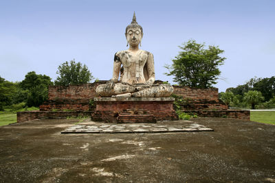 Statue against temple against sky