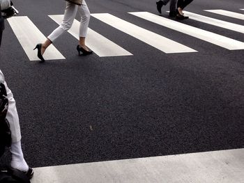 Low section of people walking on city street