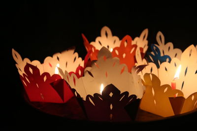 Close-up of lit candles against black background