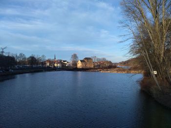 River by buildings against sky