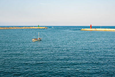 Sailboat sailing in sea against sky