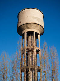 Low angle view of water tower against clear blue sky
