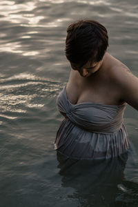 Rear view of woman standing in sea