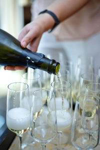 Cropped hand of person pouring champagne in glass