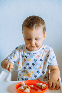 Close-up of cute girl eating food at home