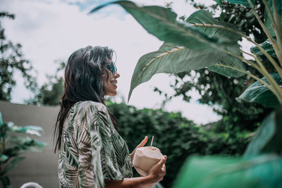 Side view of woman looking away against plants