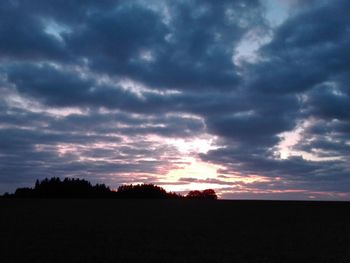 Scenic view of dramatic sky over silhouette land