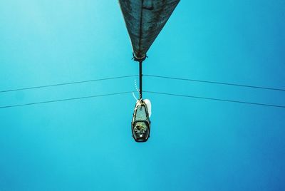 Low angle view of overhead cable car against blue sky