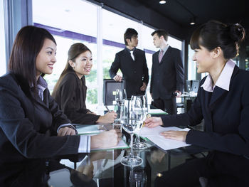 Smiling colleagues with drinks at restaurant during meeting