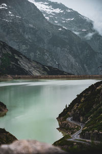 Scenic view of lake by snowcapped mountains - with curvy streets and cars in the side 