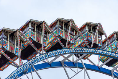 Low angle view of ferris wheel against building