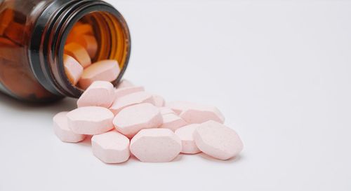 Close-up of pink bottle against white background