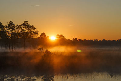 Scenic view of lake against sky during sunset