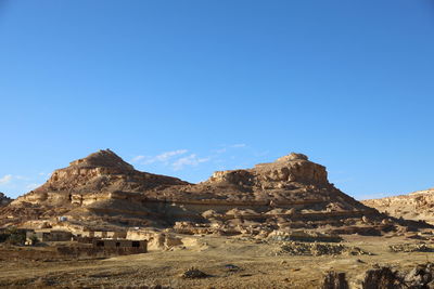 Scenic view of arid landscape against clear blue sky