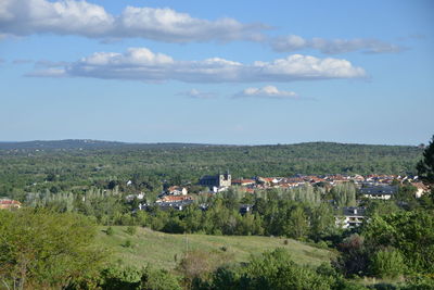 Scenic view of field and houses against sky