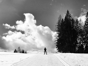 Rear view of woman standing on snow covered landscape