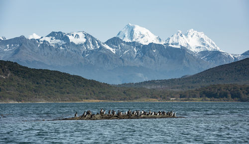 Scenic view of sea and snowcapped mountains against sky