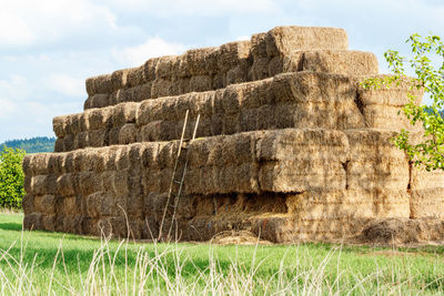 Stack of stone on field against sky