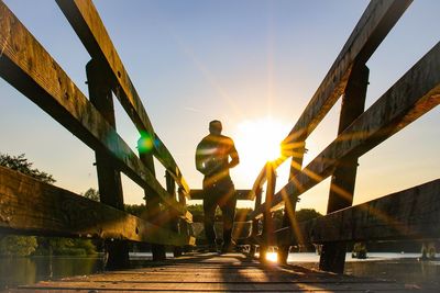 Low angle view of man standing on bridge against sky