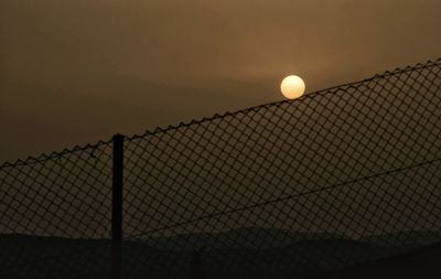 Fence against sky during sunset