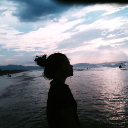 Silhouette man standing on beach against sky during sunset