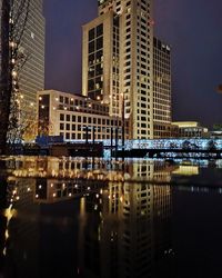 Reflection of illuminated buildings in city at night