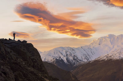 Scenic view of snowcapped mountains against sky during sunset