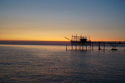 Silhouette pier on sea against sky during sunset