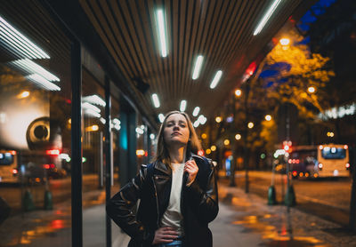 Young woman looking at illuminated city at night