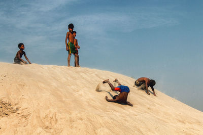 Rear view of people on sand