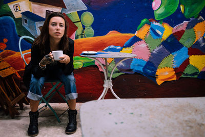 Portrait of young woman drinking coffee