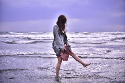 Full length of woman on beach against sky