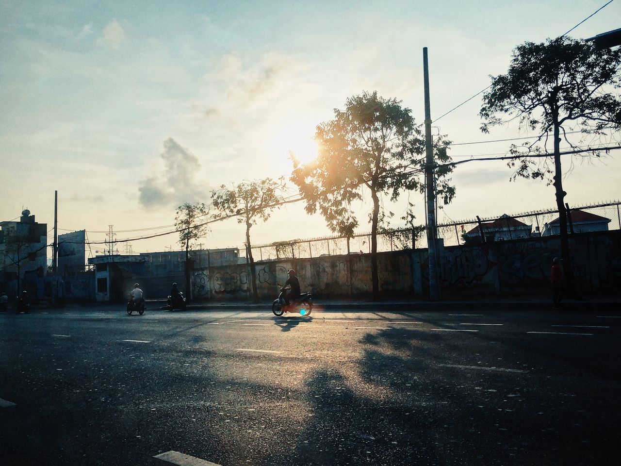 MAN SKATEBOARDING ON ROAD AGAINST SKY