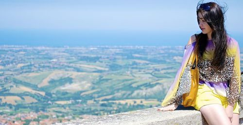 Midsection of woman standing on mountain against clear sky