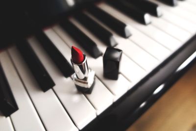 High angle view of red lipstick on piano keys