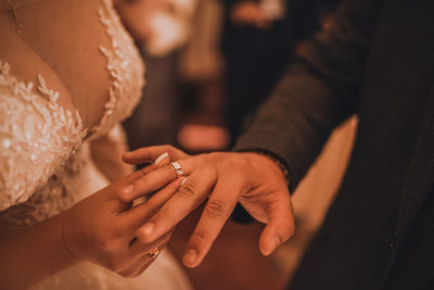 Midsection of bride holding wedding dress