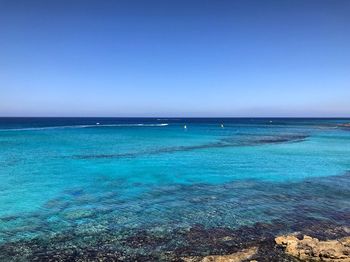 Scenic view of sea against clear blue sky