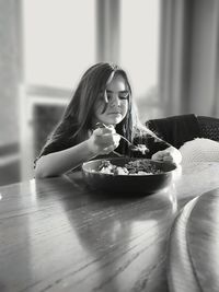 Portrait of young woman sitting on table