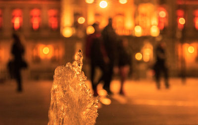 People on illuminated street at night