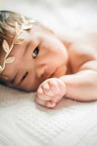 Close-up portrait of cute baby lying on bed