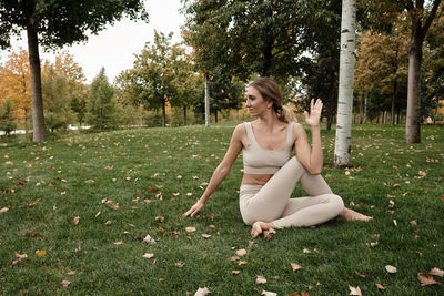 Side view of woman sitting on field