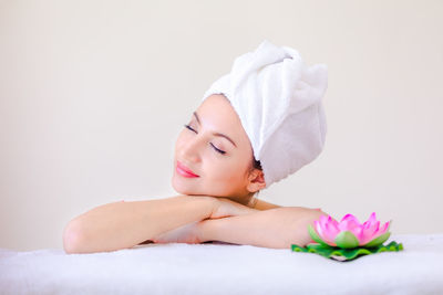 Midsection of woman lying down against white wall