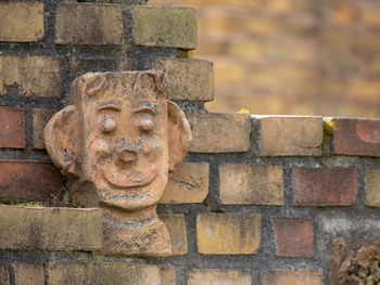 Close-up of statue against brick wall