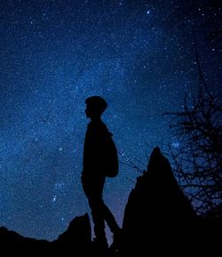 Low angle view of silhouette man standing against sky at night